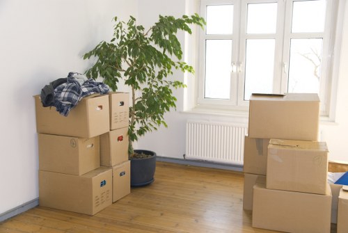 Professional movers carrying furniture through a Brent property