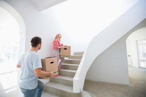 Professional movers carrying a sofa through a Brent property